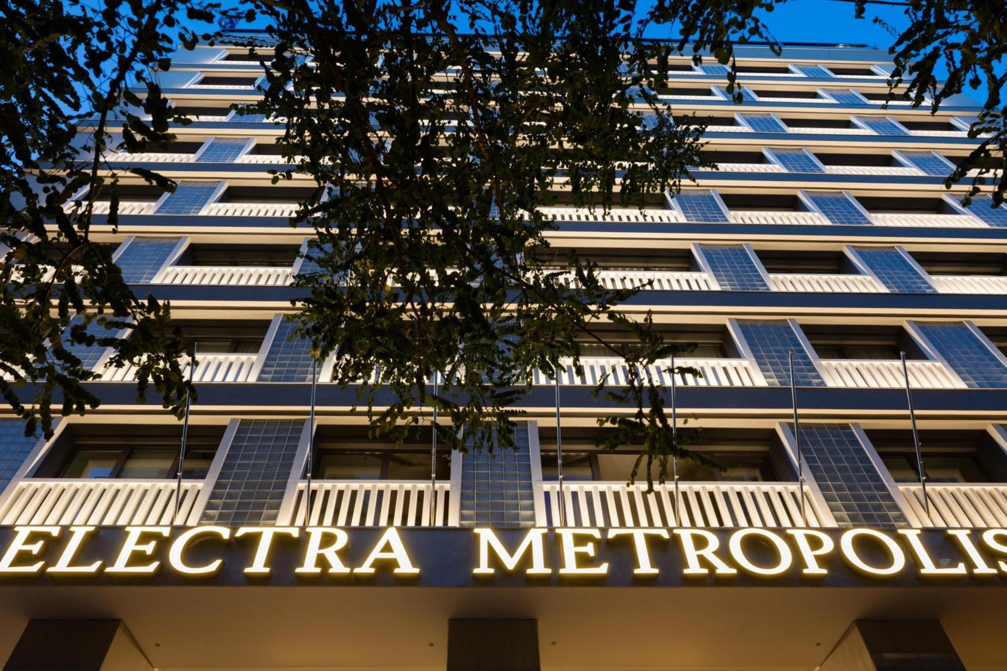 Electra Metropolis Hotel Athena Bagian luar foto The photo shows the facade of a building called "Electra Metropol." It appears to be a modern multi-story structure with balconies and large windows. The prominent sign with the name of the building is illuminated, making it stand out against the eve